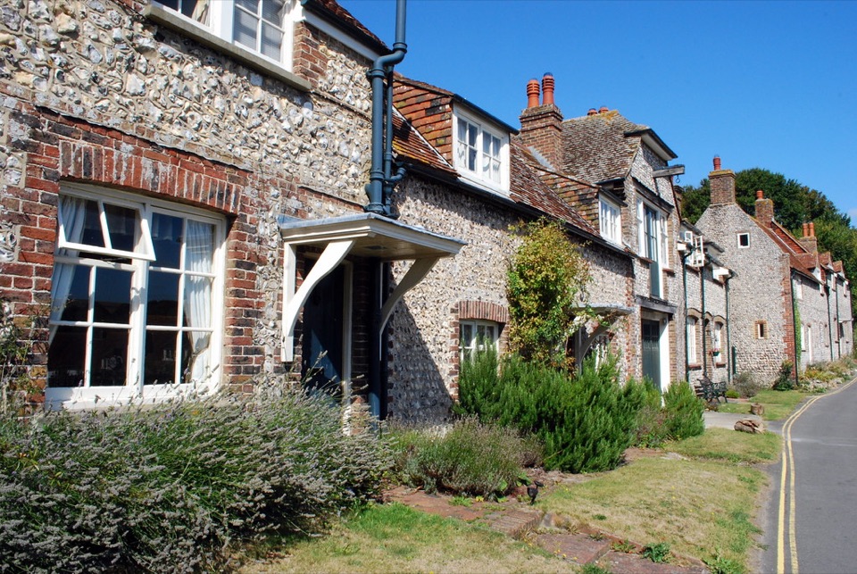 Flint and brick cottages along a lane at East Dean in East Sussex